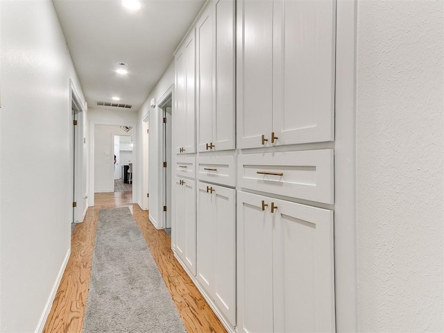 hallway with recessed lighting, light wood finished floors, visible vents, and baseboards