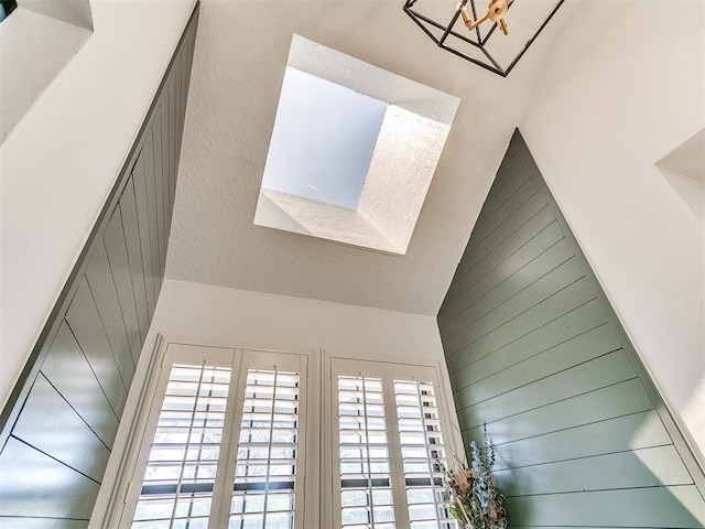 interior details featuring wood walls and a notable chandelier