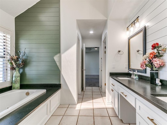 bathroom featuring a sink, a healthy amount of sunlight, tile patterned flooring, and a garden tub