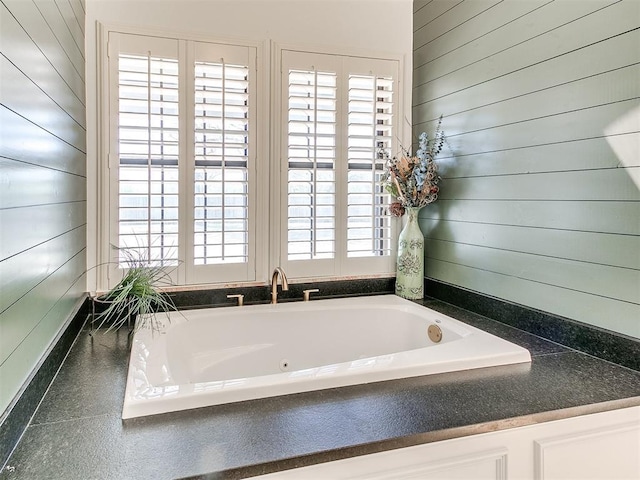 full bath featuring a jetted tub and wood walls