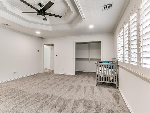 carpeted bedroom featuring ornamental molding, visible vents, and a closet