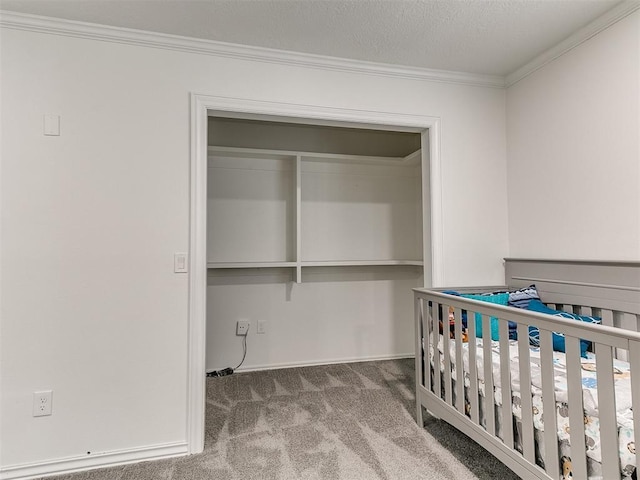 unfurnished bedroom featuring a closet, baseboards, ornamental molding, and carpet floors