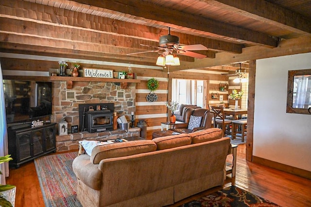 31230 N County Road 3170, Elmore City, OK 73433 - living area featuring ceiling fan, beam ceiling, a wood stove, and hardwood / wood-style floors