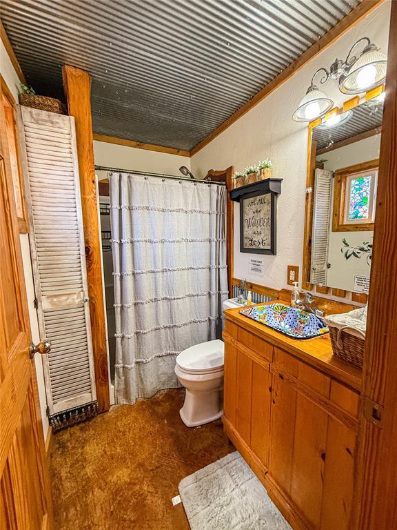 31230 N County Road 3170, Elmore City, OK 73433 - full bath featuring curtained shower, toilet, vanity, and ornamental molding