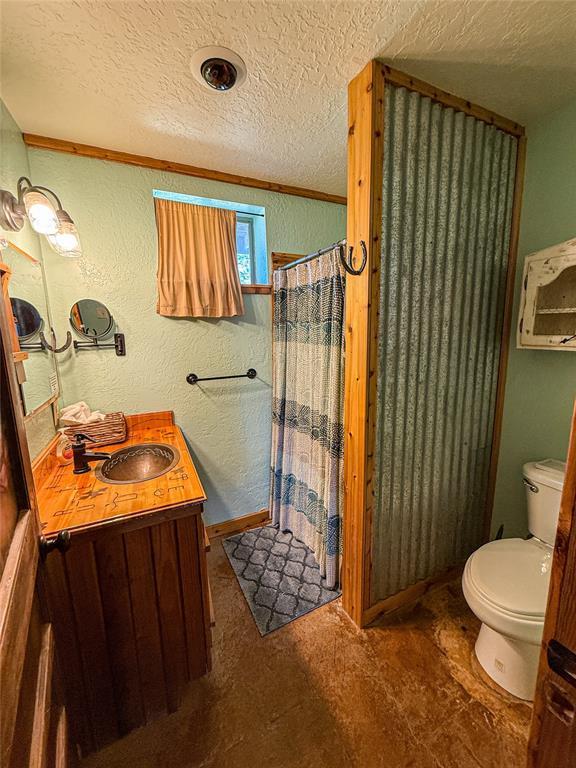 31230 N County Road 3170, Elmore City, OK 73433 - bathroom with a textured wall, curtained shower, and a textured ceiling