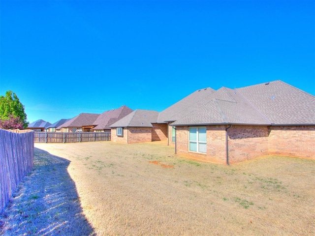 15213 Wilford Way, Edmond, OK 73013 - exterior space with brick siding, a fenced backyard, and a lawn