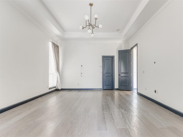 15213 Wilford Way, Edmond, OK 73013 - unfurnished room featuring a chandelier, a raised ceiling, baseboards, and light wood-style flooring
