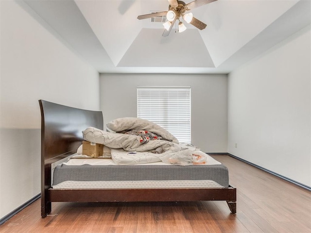 15213 Wilford Way, Edmond, OK 73013 - bedroom featuring a ceiling fan, a raised ceiling, wood finished floors, and lofted ceiling