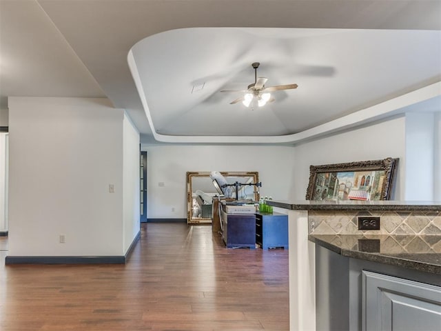 15213 Wilford Way, Edmond, OK 73013 - interior space with a raised ceiling, ceiling fan, baseboards, and dark wood-style floors