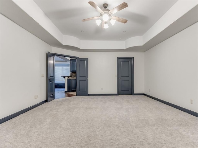 15213 Wilford Way, Edmond, OK 73013 - unfurnished bedroom with carpet flooring, a tray ceiling, baseboards, and ceiling fan
