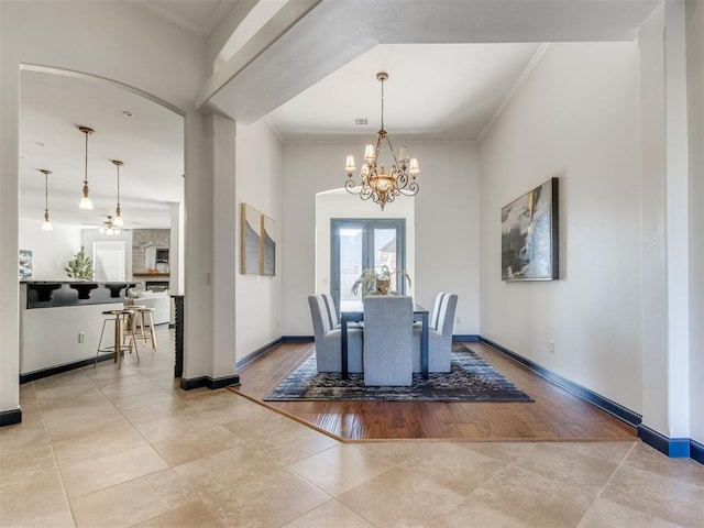 15213 Wilford Way, Edmond, OK 73013 - tiled dining room with a chandelier, arched walkways, baseboards, and ornamental molding