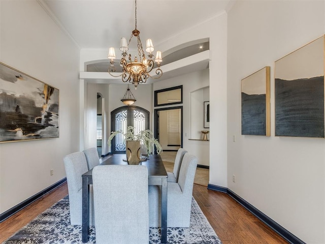 15213 Wilford Way, Edmond, OK 73013 - dining area with arched walkways, wood finished floors, an inviting chandelier, and ornamental molding