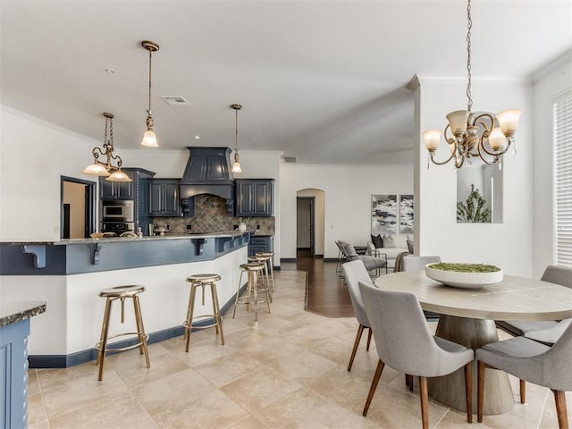 15213 Wilford Way, Edmond, OK 73013 - dining area featuring crown molding, visible vents, arched walkways, and a chandelier