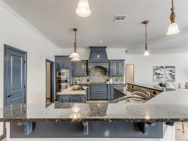 15213 Wilford Way, Edmond, OK 73013 - kitchen with premium range hood, appliances with stainless steel finishes, a breakfast bar area, and a large island with sink