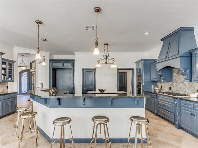 15213 Wilford Way, Edmond, OK 73013 - kitchen featuring visible vents, stainless steel appliances, decorative backsplash, blue cabinetry, and a breakfast bar area