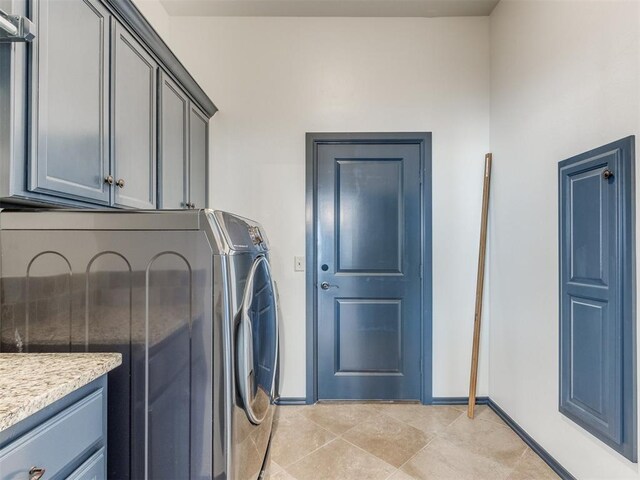 15213 Wilford Way, Edmond, OK 73013 - laundry room with light tile patterned flooring, washing machine and dryer, baseboards, and cabinet space