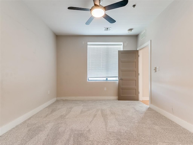 carpeted empty room with visible vents, ceiling fan, and baseboards