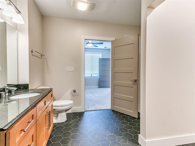 bathroom featuring vanity, toilet, a ceiling fan, baseboards, and tile patterned flooring