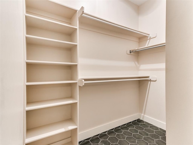walk in closet featuring dark tile patterned flooring