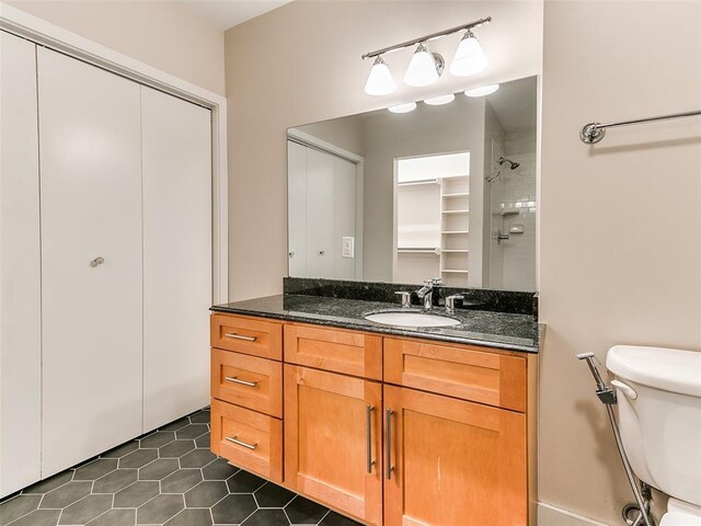 full bath with tile patterned floors, toilet, vanity, and a shower