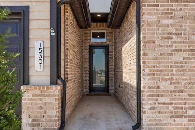 view of exterior entry featuring brick siding