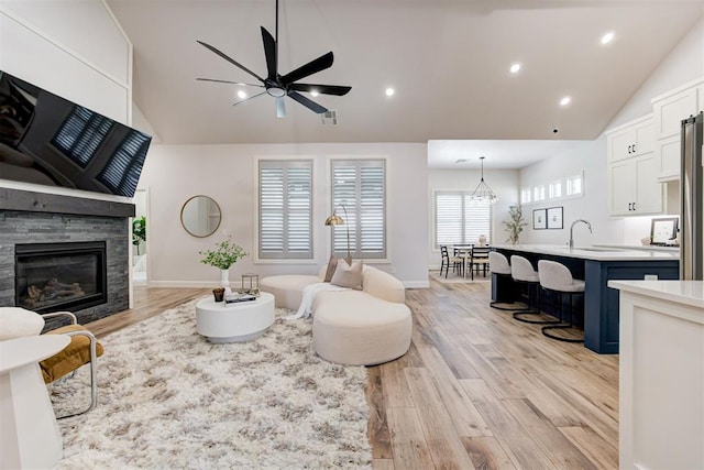 living room featuring high vaulted ceiling, visible vents, light wood-type flooring, and ceiling fan