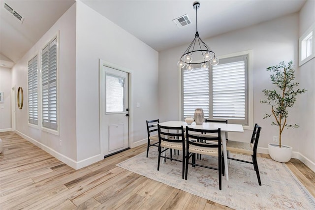 dining space with light wood finished floors, baseboards, and visible vents
