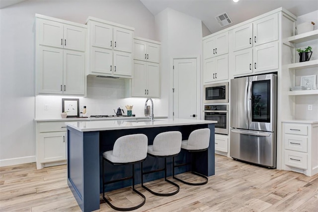 kitchen with visible vents, open shelves, a sink, light countertops, and stainless steel appliances