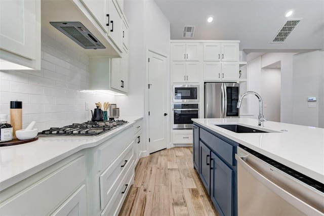 kitchen with visible vents, white cabinetry, a sink, and appliances with stainless steel finishes