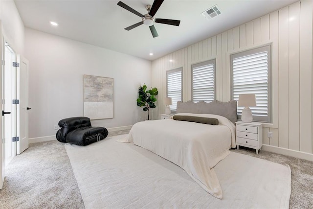 carpeted bedroom featuring a ceiling fan, baseboards, multiple windows, and visible vents