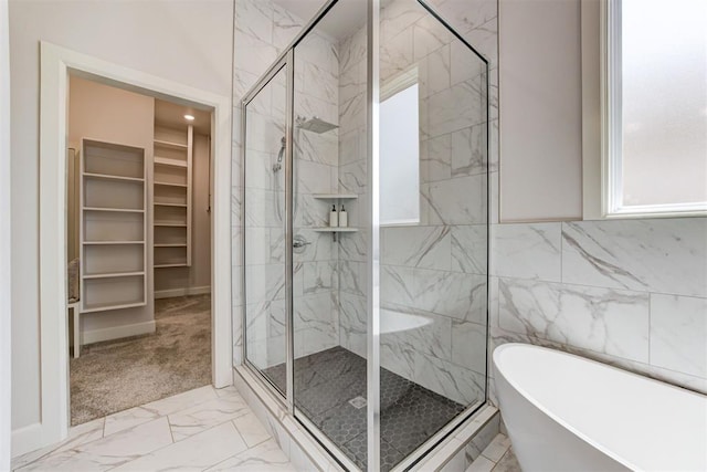 bathroom with a shower stall, plenty of natural light, marble finish floor, and a soaking tub