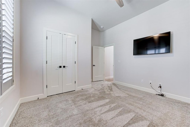unfurnished bedroom with carpet floors, baseboards, and vaulted ceiling