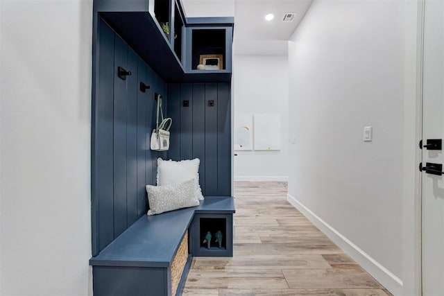 mudroom featuring visible vents, baseboards, and light wood-style floors