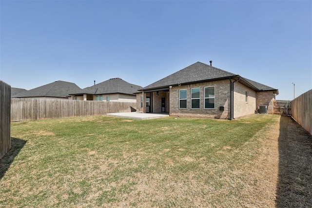 rear view of property with a patio area, a fenced backyard, brick siding, and a yard