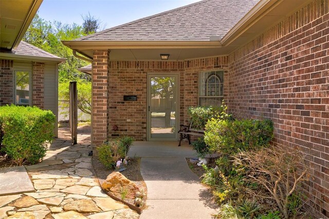 4408 32nd Pl, Oklahoma City, OK 73112 - doorway to property with a shingled roof and brick siding