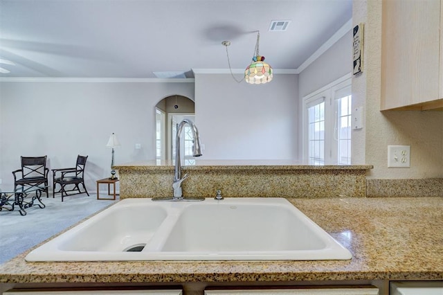 4408 32nd Pl, Oklahoma City, OK 73112 - kitchen featuring ornamental molding, visible vents, carpet flooring, a sink, and hanging light fixtures