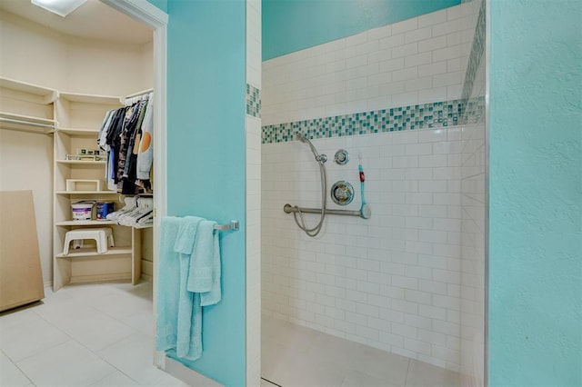 4408 32nd Pl, Oklahoma City, OK 73112 - bathroom featuring a textured wall, a walk in closet, a tile shower, and tile patterned flooring
