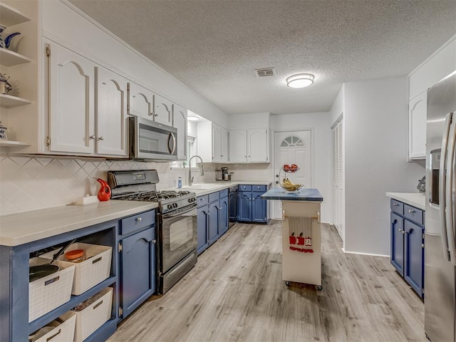 kitchen with a sink, blue cabinetry, open shelves, and black appliances