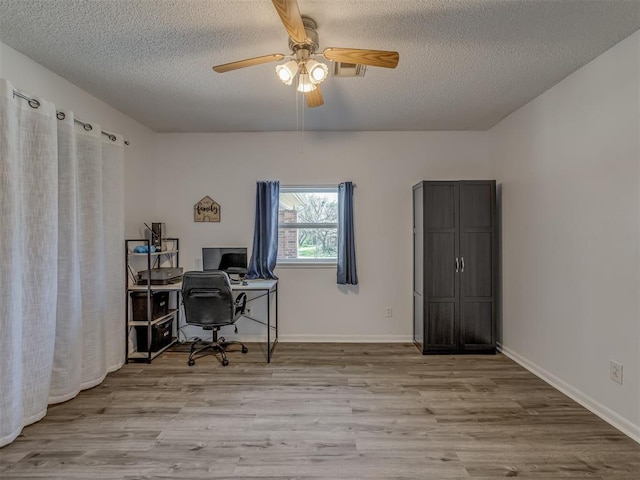 office featuring baseboards, a textured ceiling, a ceiling fan, and wood finished floors