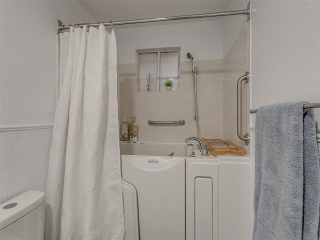 bathroom with a shower with shower curtain, a bathtub, and toilet