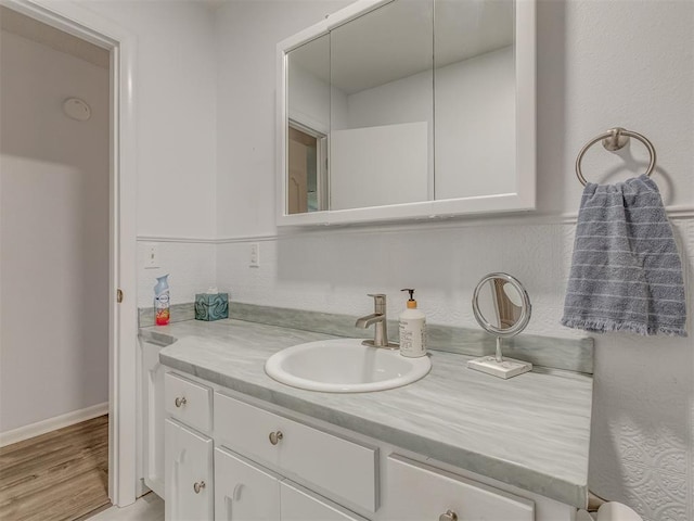 bathroom with wood finished floors and vanity