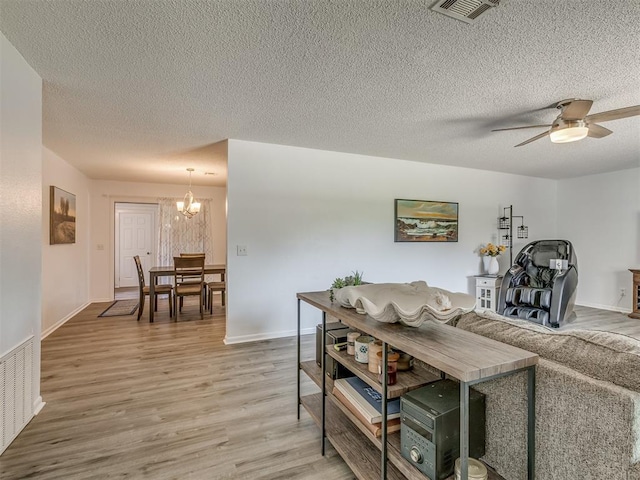 721 Ladd Ave, Depew, OK 74028 - living area featuring light wood-style floors, a textured ceiling, a chandelier, and ceiling fan