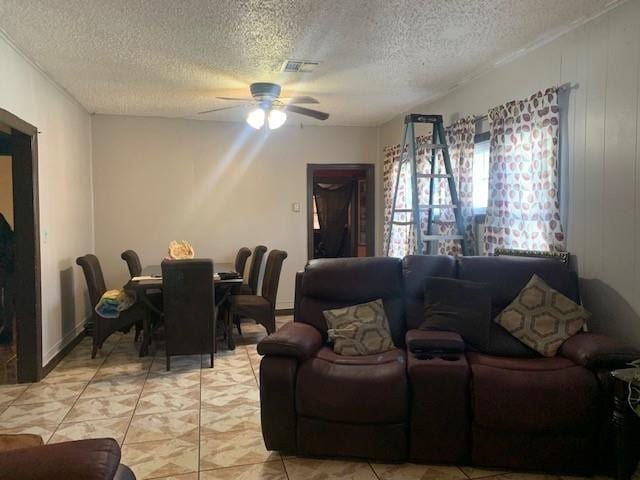 4115 S Shields Blvd, Oklahoma City, OK 73129 - living room with light tile patterned flooring, a textured ceiling, ceiling fan, and visible vents