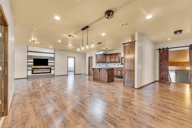 kitchen featuring open floor plan, a kitchen island, a barn door, and visible vents