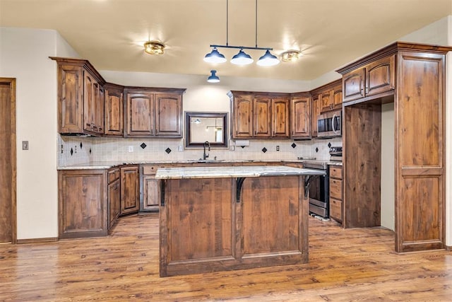 kitchen with tasteful backsplash, wood finished floors, and stainless steel appliances