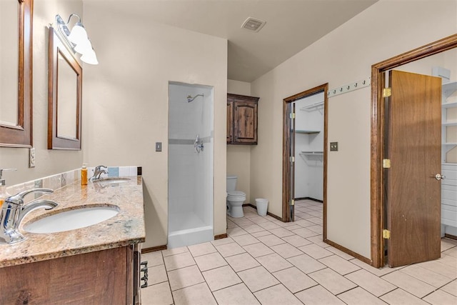bathroom with baseboards, a stall shower, a sink, and toilet