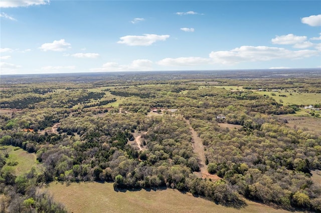 drone / aerial view featuring a wooded view