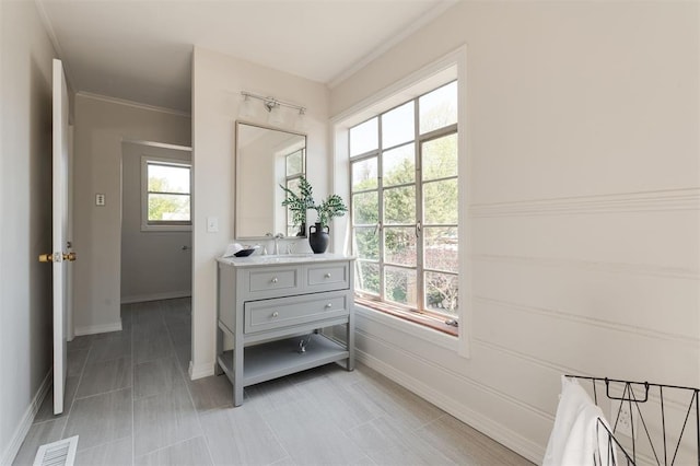 905 NW 40th St, Oklahoma City, OK 73118 - bathroom with ornamental molding, visible vents, baseboards, and vanity