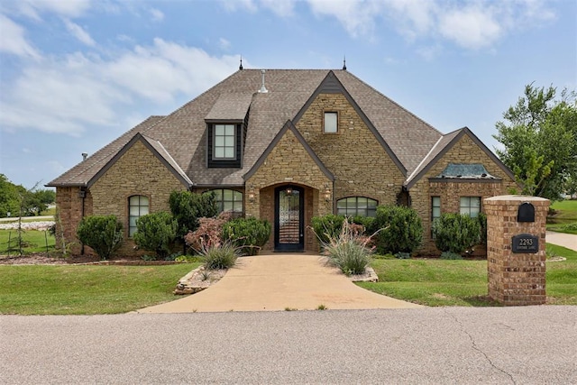 2293 Cottage Ln, Blanchard, OK 73010 - tudor-style house with stone siding, a front lawn, roof with shingles, and brick siding