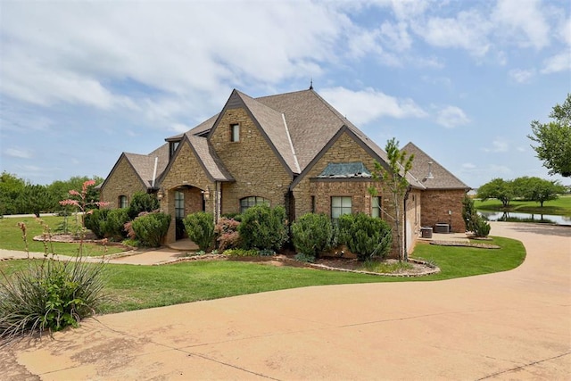 2293 Cottage Ln, Blanchard, OK 73010 - view of front of house featuring a front lawn, stone siding, brick siding, and a water view